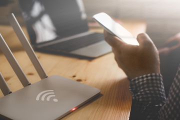 Person on phone next to wifi router