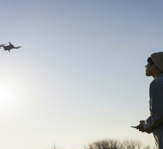 Young man flying a drone in the early morning