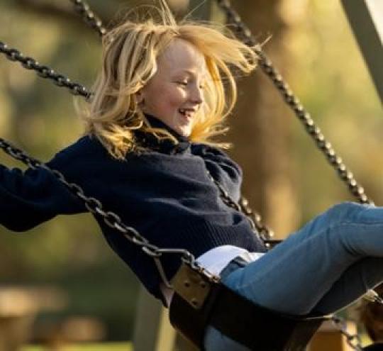 Girl on a swing in the sunshine