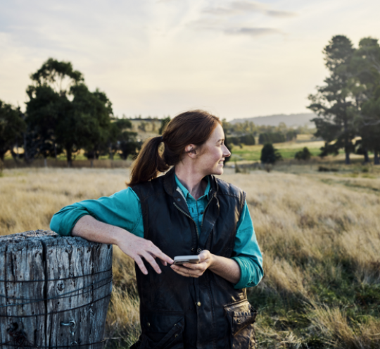 Young farmer staying in touch via mobile technology from their rural farm