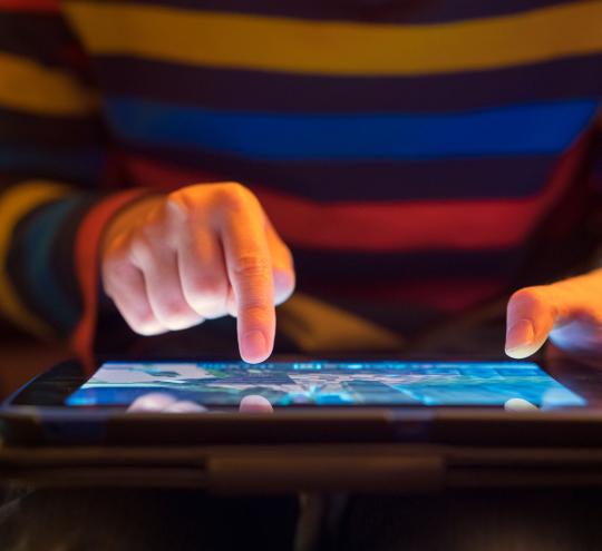 Close up of a young boy using a tablet.