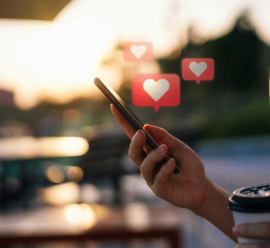 Person holding phone with heart icons