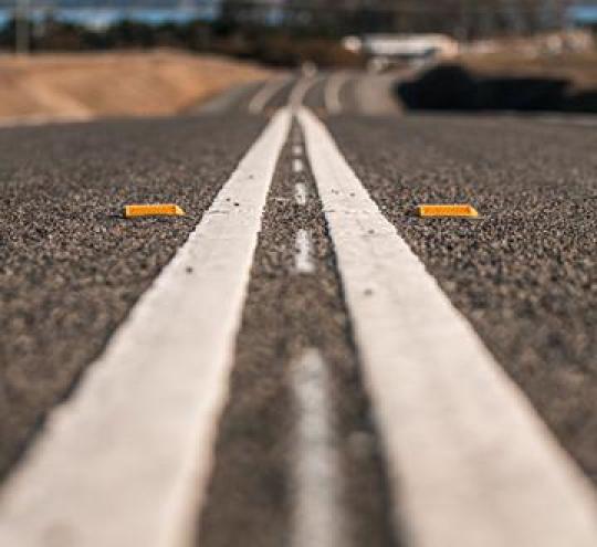 White double lines painted in the middle of a black road.