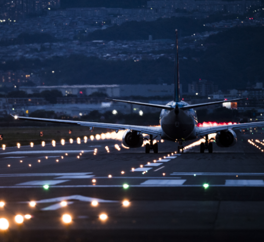 Plane taking off from a run-way at night.