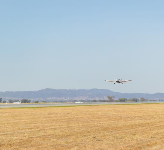 Small plane preparing to land on an airstrip.