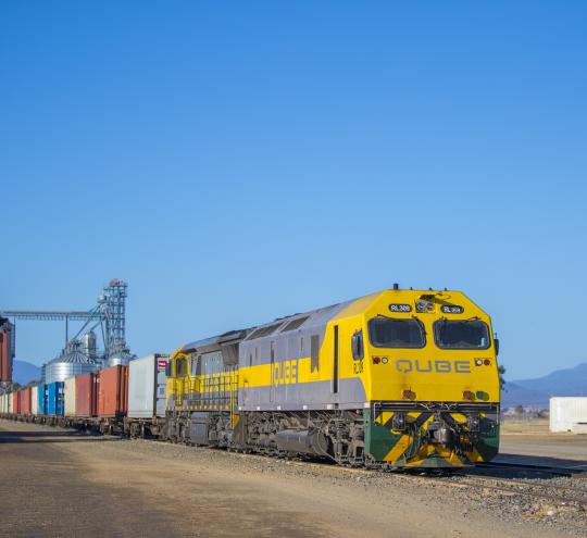 Freight train being loaded with containerised cargo.