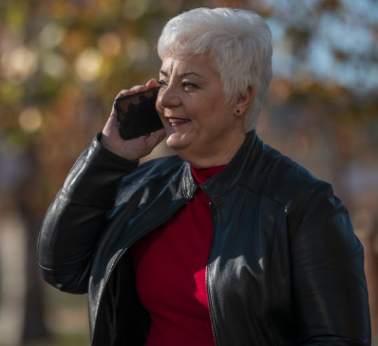 Woman sitting on an outdoor bench talking on a mobile phone.