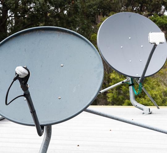 VAST review. Image of two satellite dishes on a roof.