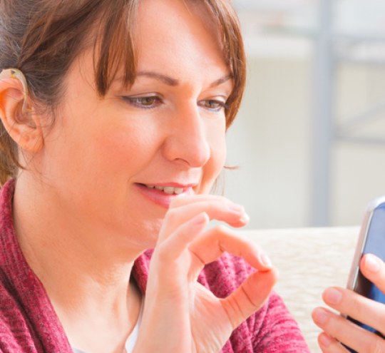 Woman signing into a mobile phone device.