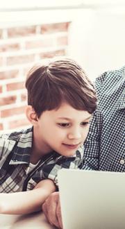 Child and grandfather looking at computer tablets