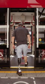 man with prosthetic leg boarding a train