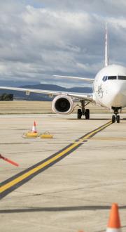 Ground crew guides airplane as it taxis on runway 