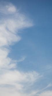 Cellular network tower with cloudy blue sky back-drop