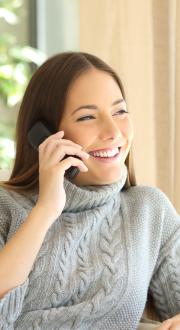 person smiling whil talking on the phone