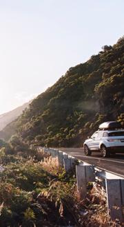 Car driving along a scenic coastline.