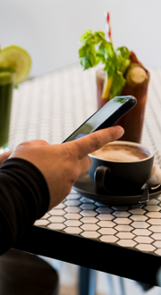 Person at a cafe shop looking at their mobile phone