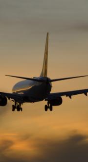 Plane coming in to land with sunset sky in the background