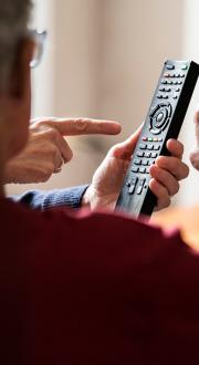 elderly man using tv remote