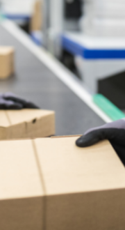 Workers in high visibility clothing handling parcels on a conveyer belt.