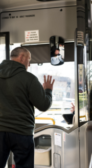 Man waving to bus driver as he exits the bus.