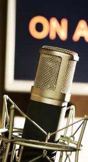 Microphone in radio studio with On Air sign.