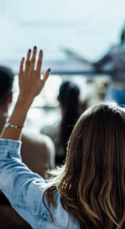 Back view image of a woman raising her hand in a presentation