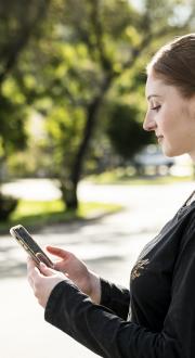 A woman standing on the street, looking at her phone