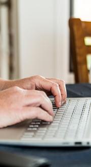 women typing on notebook computer