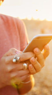 Women texting on her phone on a beach at sunset