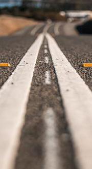 White double lines painted in the middle of a black road.