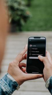 Man holds a smart phone, which shows a dating app.