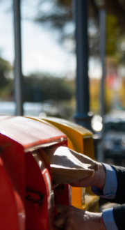 Man posting a letter into an Australia Post mail box.