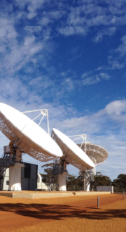 Image of satellite ground station with blue sky and clouds in the background.