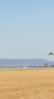 Small plane preparing to land on an airstrip.