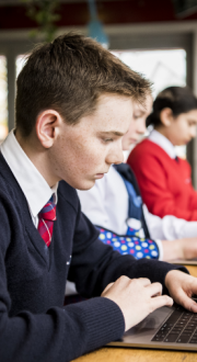 Teenager sitting at a desk with a laptop