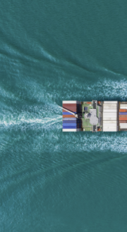 An aerial photo of a large cargo vessel ship moving across the ocean