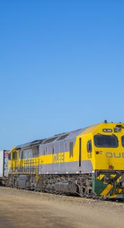 Freight train being loaded with containerised cargo.