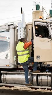 Truck driver enters parked vehicle through driver door.