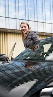 woman getting in to the driving seat of a car smiling