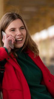 Woman at train station talking on mobile.