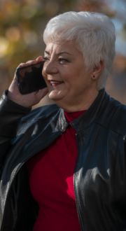 Woman sitting on an outdoor bench talking on a mobile phone.