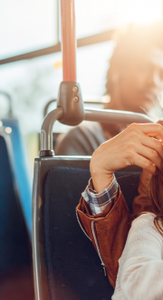  A mother and child are sitting in a bus looking at a phone together.