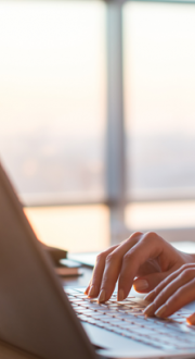 Woman using a laptop on an office desk.