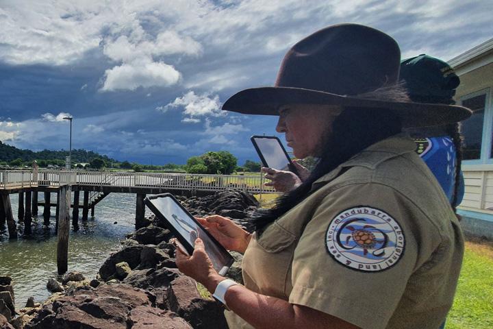 woman using tablet overlooking a pier