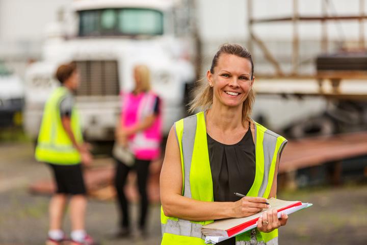 woman in high visibility vest holding a logbook